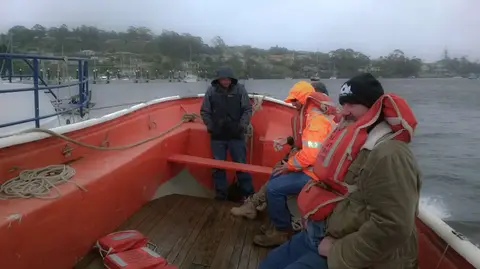 Cold wet miserable Cox being towed