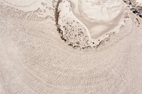 Mud Spring. Mud bubbles up from within the earth. It is cold, not hot. The darker color is oil.