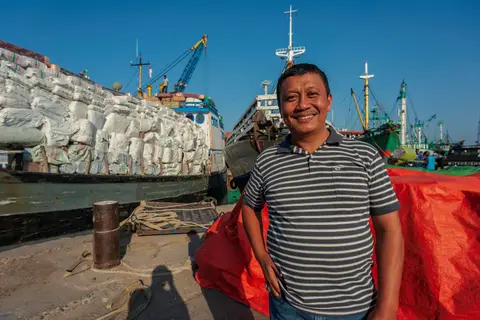 Local Shipping in Surabaya. My guide to Surabuya in front of what seems like a very overloaded ship.