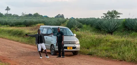 Dawn on the way to Pangani. Charles on the left and George, the driver, on the right. Sisal plants in the background.