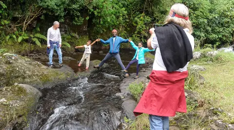 Crossing a Stream. Simon Mtuy helps the girls keep their feet dry.