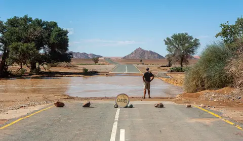 How Deep Is It?. Matt contemplates the river after a flash flood closes the road to Sossosvlei.
