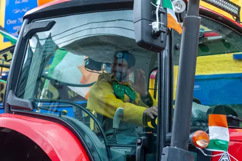Green Man in a BIG Tractor. Muscle farmer in his shiny new machine.
