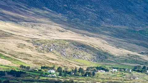 Over the Water. Knocknadobar towers over the settlement at its foot. The sheep on those farms all have two legs longer than the others.